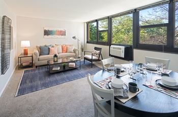 Living room layout with couch, dining set, and large windows